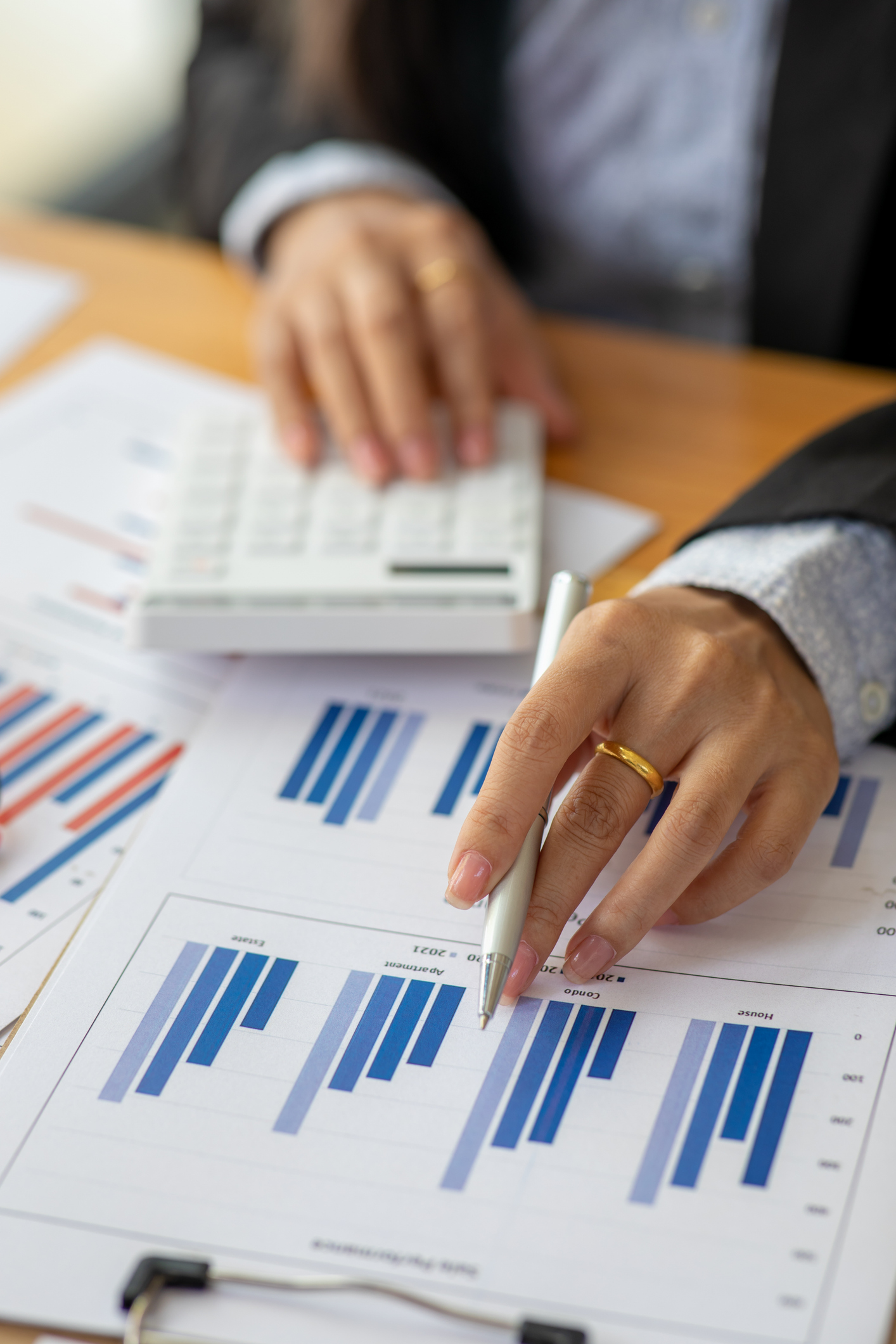 Close up of Business using calculator and laptop for doing math finance report on wooden desk, tax, accounting, statistics and analytical research concept